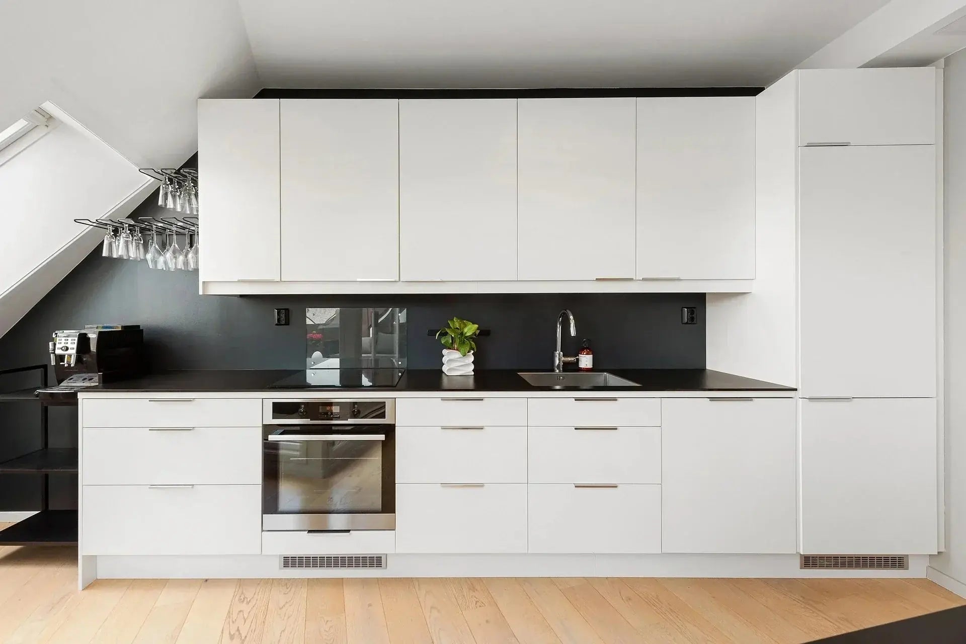 A modern kitchen featuring white cabinets, black countertops, and a stylish kitchen sink, showcasing best kitchen sinks from top brands.