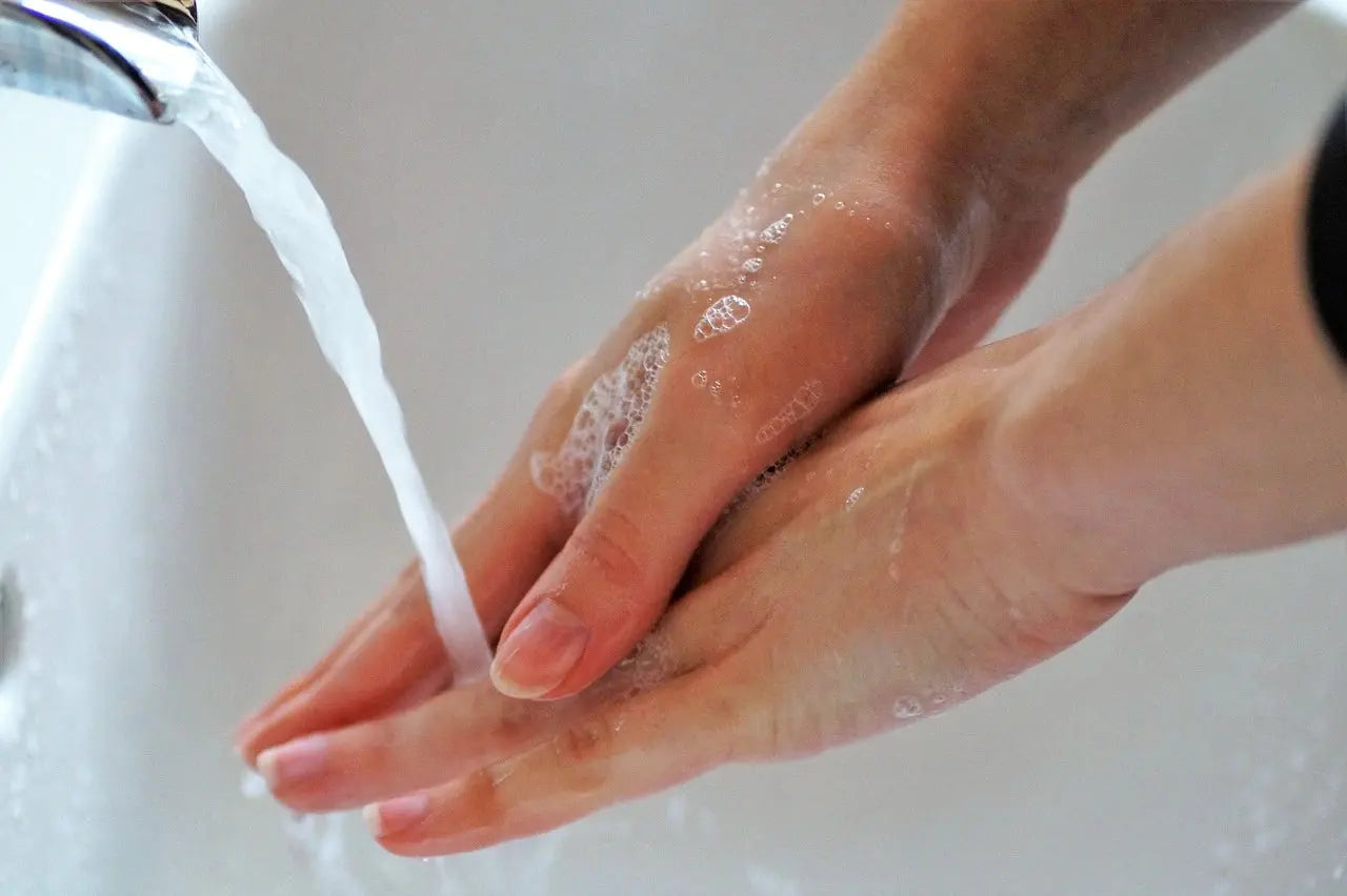 A person thoroughly washing their hands with soap and water at a sink, promoting hygiene and cleanliness, using high-quality Bathtub and Shower Faucets to ensure optimal water flow and control.