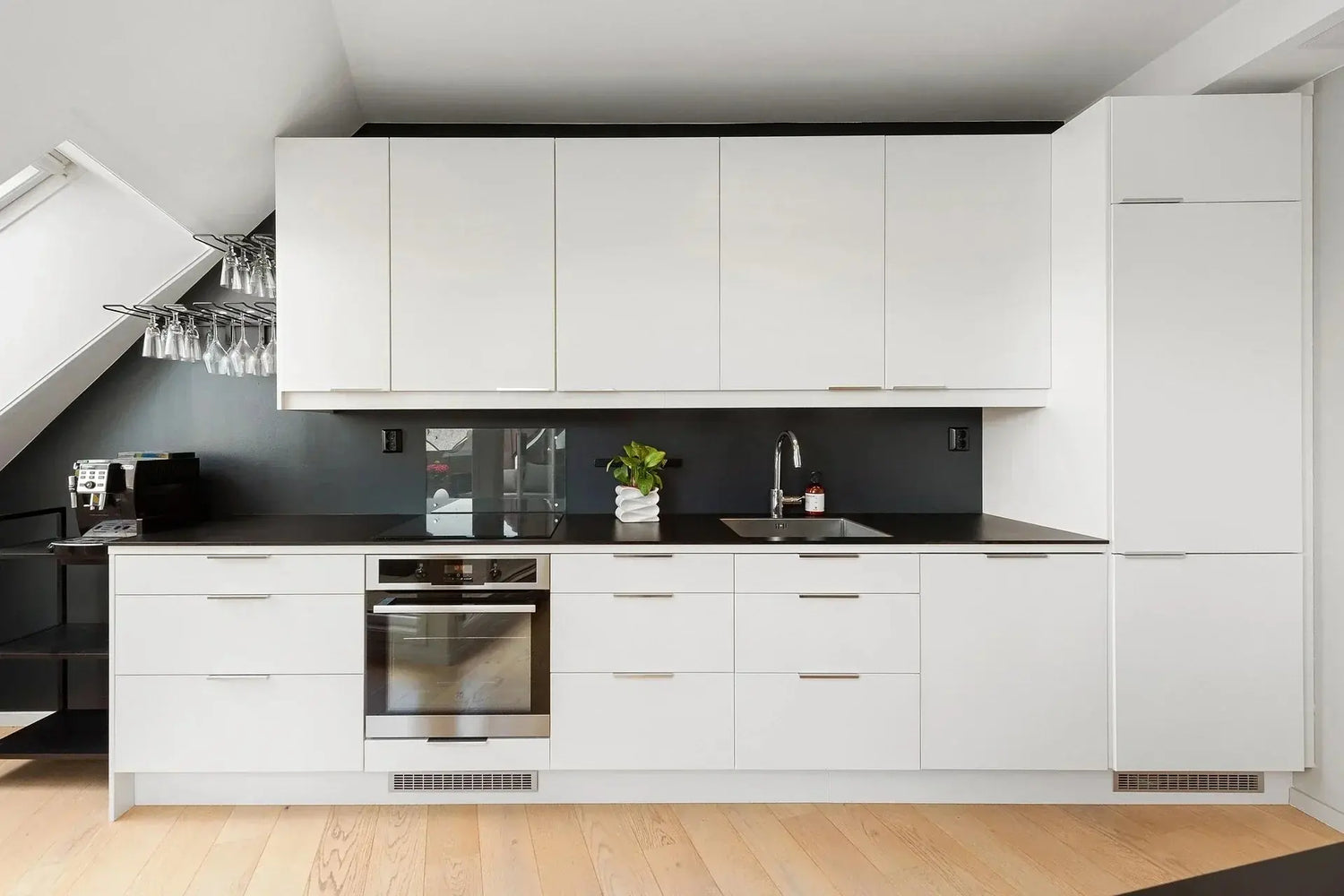 A modern kitchen featuring white cabinets, black countertops, and a stylish kitchen sink, showcasing best kitchen sinks from top brands.