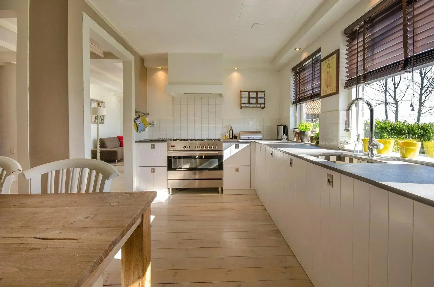 A cozy kitchen featuring a table and chairs, complemented by a stylish kitchen faucet.